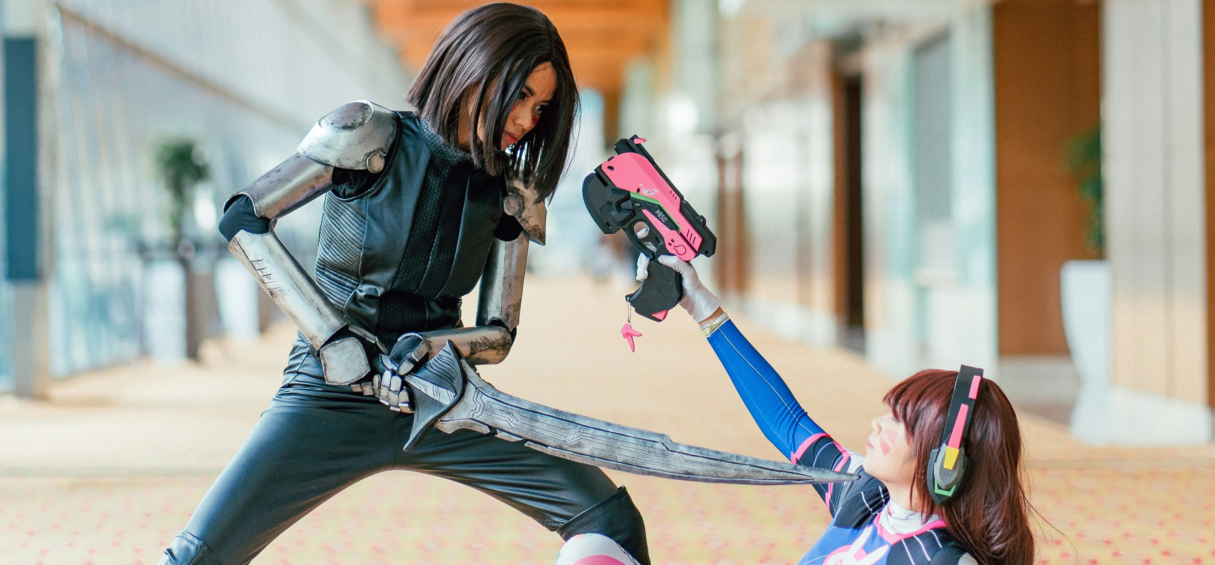 two cosplayers posing with foam props